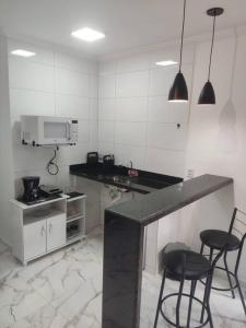 eine Küche mit 2 Stühlen und einer Theke mit einer Mikrowelle in der Unterkunft Casa Nova Centro de Penedo in Penedo