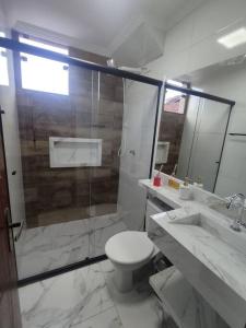 uma casa de banho com um WC, um chuveiro e um lavatório. em Casa Nova Centro de Penedo em Penedo