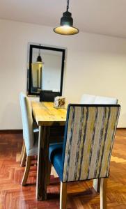 een houten tafel met 2 stoelen en een spiegel bij Confortable & estiloso departamento en la ciudad de Mendoza in Mendoza