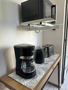 - un comptoir de cuisine avec une cafetière et un four micro-ondes dans l'établissement Confortable & estiloso departamento en la ciudad de Mendoza, à Mendoza