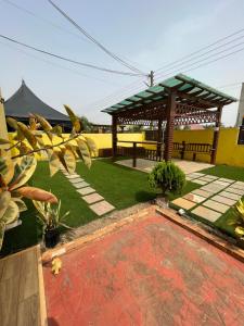 a garden with a gazebo and a picnic shelter at Chez nous house in Accra