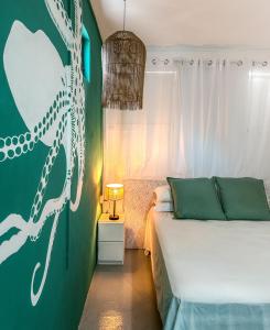 ein Schlafzimmer mit einem Bett und einer grünen Wand in der Unterkunft La villa detente - Une experience authentique in Rodrigues Island