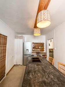 a kitchen with a large table and a refrigerator at La villa detente - Une experience authentique in Rodrigues Island