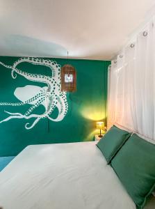 1 dormitorio con 1 cama con un pulpo pintado en la pared en La villa detente - Une experience authentique, en Rodrigues Island