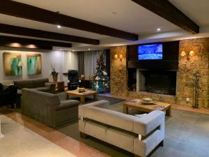 a living room with a christmas tree and a fireplace at Apart-hotel em Gramado, padrão 4 estrelas, no centro in Gramado