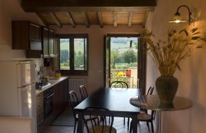 Castel RitaldiにあるBorgo Le Capannelleのキッチン(テーブル、椅子、テーブル、窓付)