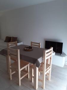 a dining room table with chairs and a television at Vento Apart in Chivilcoy