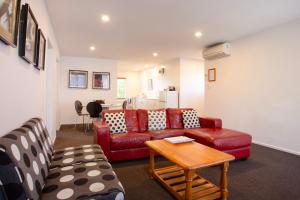 uma sala de estar com um sofá e uma mesa em Casino Court Motor Lodge em Christchurch