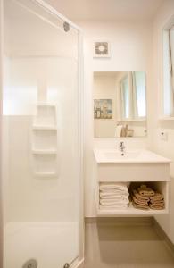 een witte badkamer met een wastafel en een douche bij Casino Court Motor Lodge in Christchurch