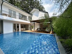 a large blue swimming pool in front of a house at Bungalow Homes in Bandung