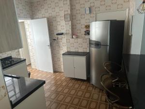 uma cozinha com um frigorífico de aço inoxidável e armários em Apto a 250m da praia Enseada no Guarujá
