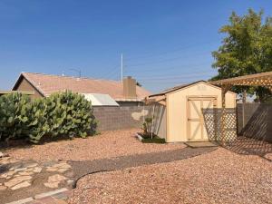 a small shed in a yard next to a house at Enjoy Fruits Of Your Labours At Grape Dr- View 3D in Las Vegas