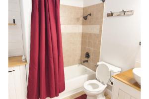 a bathroom with a red shower curtain and a toilet at Enjoy Fruits Of Your Labours At Grape Dr- View 3D in Las Vegas