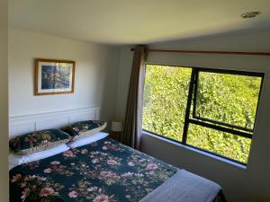 um quarto com uma cama e uma janela em City View Guest House em Gisborne