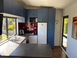 uma cozinha com armários azuis e um frigorífico branco em City View Guest House em Gisborne