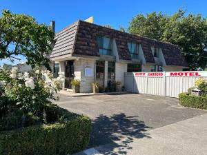 un bâtiment avec un parking en face d'un garage dans l'établissement City Gardens Motel, à Traralgon