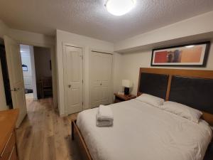 sypialnia z dużym białym łóżkiem z drewnianym zagłówkiem w obiekcie Rocky Mountain Getaway w mieście Canmore