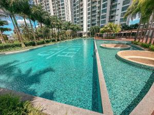 a large swimming pool with palm trees and buildings at [Starry x GREEN @GreenHaven]3Beds2Bath in Masai