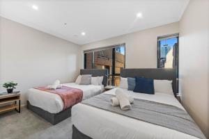 2 camas en una habitación con 2 ventanas en Regency Towers, en Melbourne