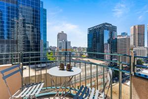 a balcony with chairs and a table with a view of a city at Regency Towers in Melbourne