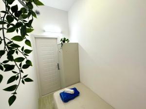 a bathroom with a white door and a plant at Striped Partition Room in Barsha 1 Near Mall of the Emirates in Dubai