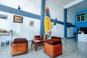 um quarto com cadeiras e uma prancha de surf na parede em iTalay Krabi em Ban Suan