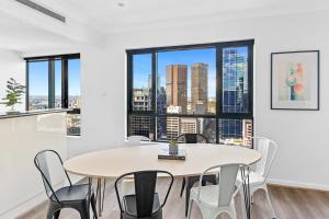 a dining room with a table and chairs and a large window at Regency Towers in Melbourne +28 photos