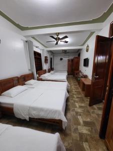 a room with four beds and a ceiling fan at Thac Tien Village Ba Vi in Ba Vì