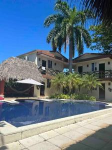una piscina con sombrilla y una casa en Casa Gaviota, en Puerto San José