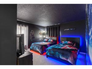 duas camas num quarto com luzes azuis em Best place to unwind and have lots of fun! em Kissimmee