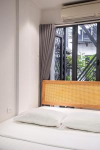 a bed in a room with a window at Lanha Hotel - Homestay in Hanoi