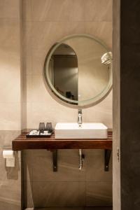 ein Bad mit einem Waschbecken und einem Spiegel in der Unterkunft Lanha Hotel - Homestay in Hanoi