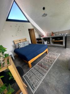 ein Schlafzimmer mit einem Bett und einem großen Fenster in der Unterkunft Cabaña Encino Saúco in Malinalco