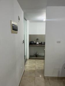 Dieses weiße Zimmer verfügt über eine Küche mit einer Theke. in der Unterkunft Ica tierra del sol eterno 1 in Ica