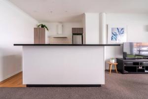 - un grand comptoir blanc dans une pièce avec une cuisine dans l'établissement Luxury Apartment With Stunning Harbour & City View, à Auckland