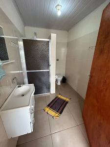 a bathroom with a shower and a sink and a toilet at Casa junto a natureza in Dourados