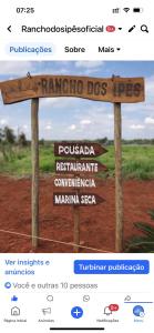 a sign in the middle of a field with some signs at Casa junto a natureza in Dourados