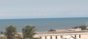 um edifício com palmeiras em frente ao oceano em Lugar de paz! em Marataizes
