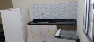 uma pequena cozinha com um lavatório e um frigorífico em Lugar de paz! em Marataízes