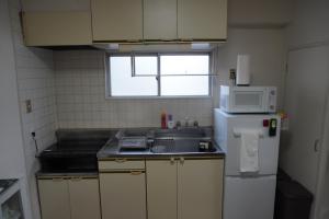 a small kitchen with a sink and a microwave at Crest YS Chiyoda 5A in Nagoya