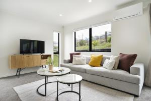 a living room with a couch and a tv at Stunning 3 bedrooms house in Hillcrest - Close to Waikato University & Cambridge in Hamilton