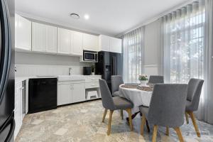 una cucina con tavolo e sedie in una cucina di New Haven - Grand Canal View Suite a Banksia Beach