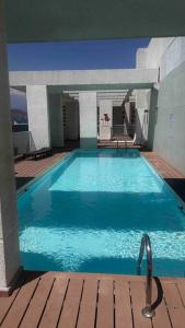une grande piscine bleue dans une maison dans l'établissement Apartamento en Las Condes frente a parque araucano, à Santiago