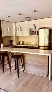 - une cuisine avec un grand comptoir et un réfrigérateur dans l'établissement Apartamento en Las Condes frente a parque araucano, à Santiago