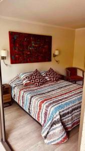 um quarto com uma cama e um quadro na parede em Apartamento en Las Condes frente a parque araucano em Santiago