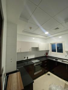 a large kitchen with white cabinets and a tv at Spacious Mini Partition Room Near Emirates Mall in Dubai