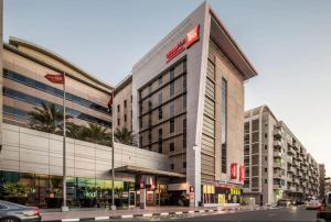 a large building on a city street with a car at Spacious Mini Partition Room Near Emirates Mall in Dubai