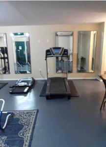 a room with a gym with a treadmill and mirrors at Branson King Resort in Branson