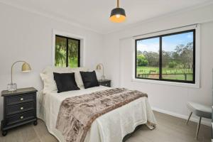 Habitación blanca con cama y ventana en Silverhill Cottage, en Exeter