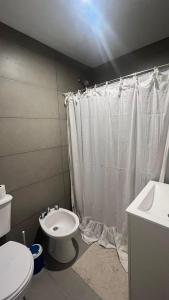 a bathroom with a white shower curtain and a toilet at Duplex alquiler Mar del Plata in Mar del Plata